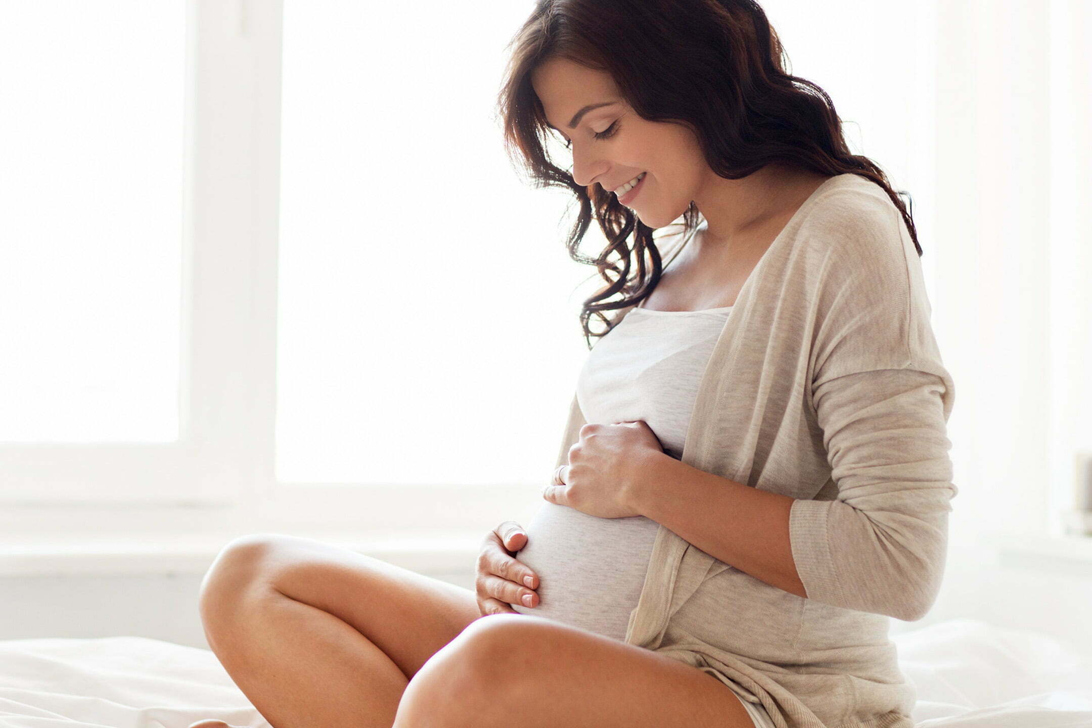 Happy pregnant lady sitting